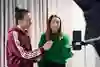 En kvinna står bredvid en kvinna som håller i en mikrofon.