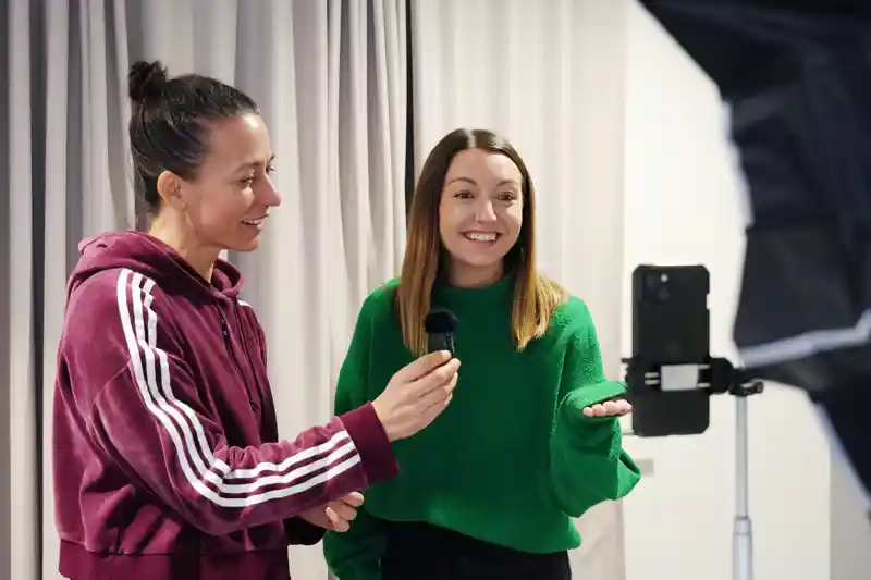 En kvinna står bredvid en kvinna som håller i en mikrofon.