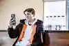 Ung kille som sitter och pratar i telefon med videosamtal.