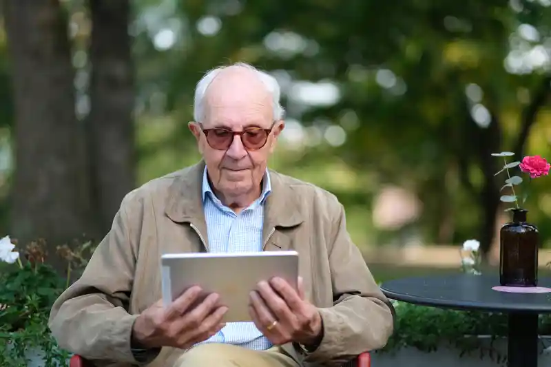 Äldre man med läsplatta