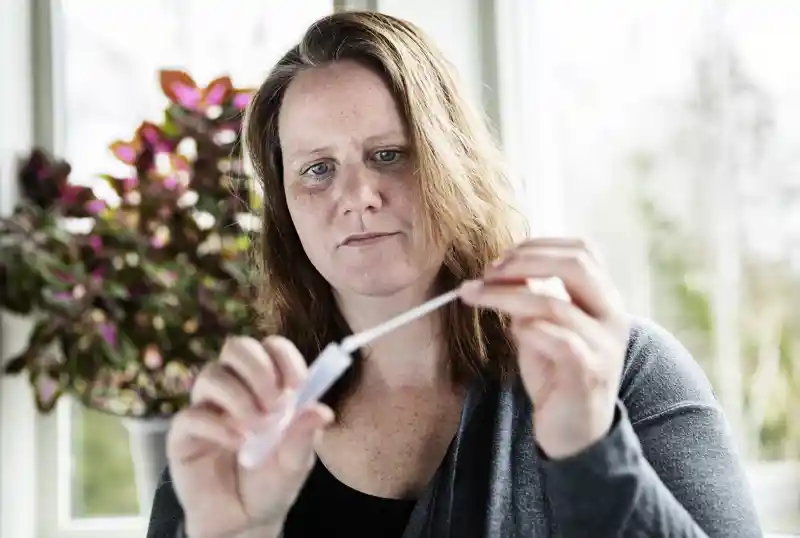 Person håller i ett provrör.
