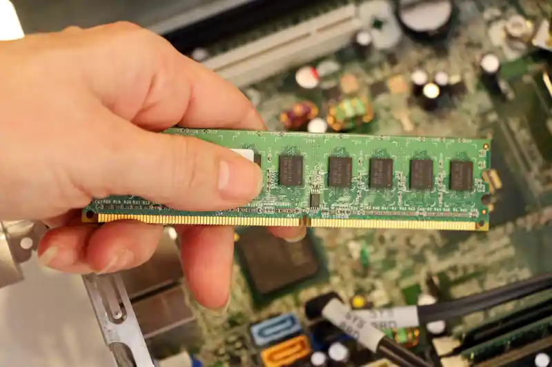 Hand håller ett mindre kretskort mot ett större.