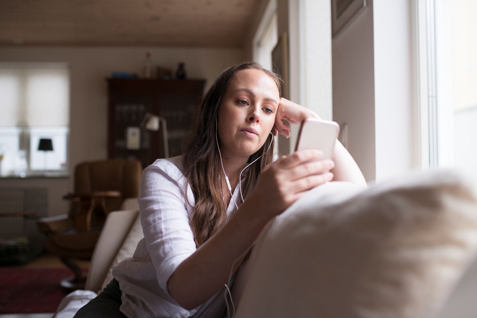 Kvinna lyssnar på musik via smartphone.
