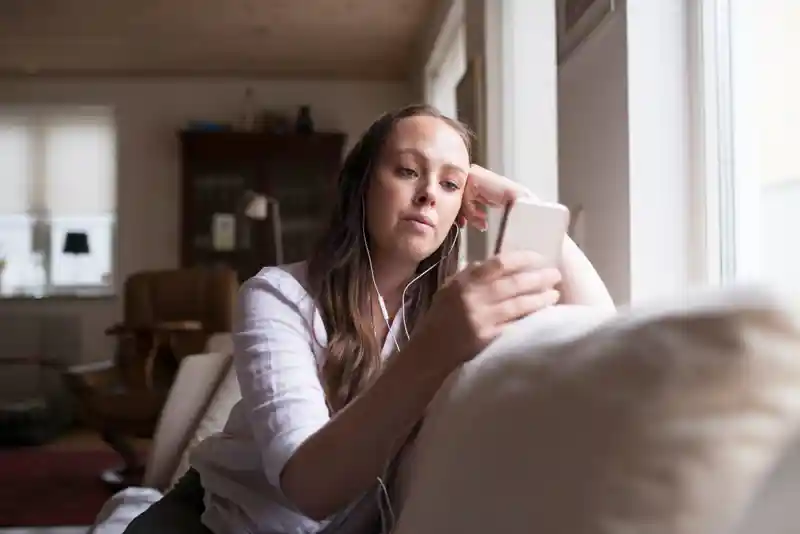 Kvinna lyssnar på musik via smartphone.