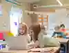Två glada, unga skolflickor som tittar på en bärbar dator.