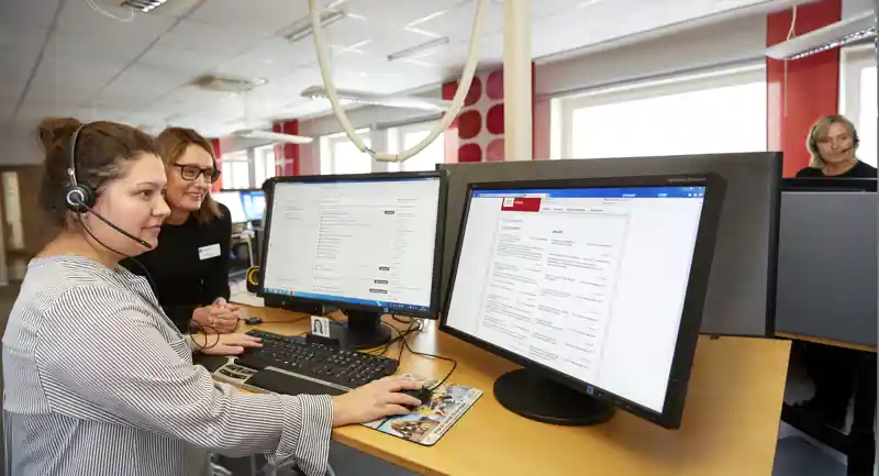 Två medarbetare på sjukvårdsrådgivningen i Östergötland betraktar informationen på en datorskärm.