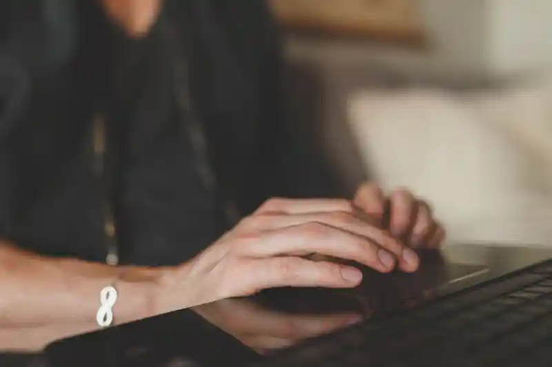 Händer på ett tangentbord till en bärbar dator