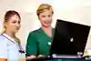 En sjuksköterska och en läkare studerar information på datorskärm